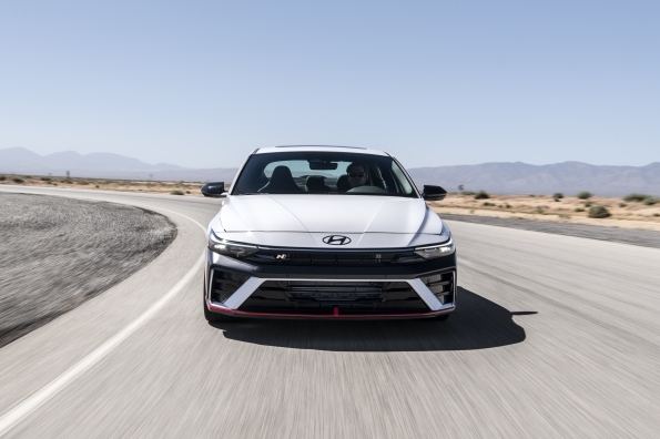 2024 현대 아반떼 N 정측면 – 흰색 바디, 날렵한 헤드램프, N 로고가 적용된 대형 프론트 그릴과 스포티한 범퍼 디자인